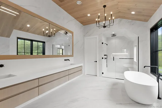 a spacious bathroom with a large tub shower and mirror
