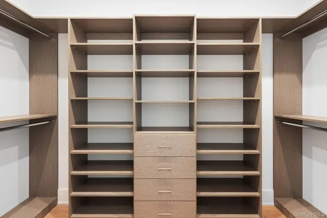 a view of walk in closet with empty racks