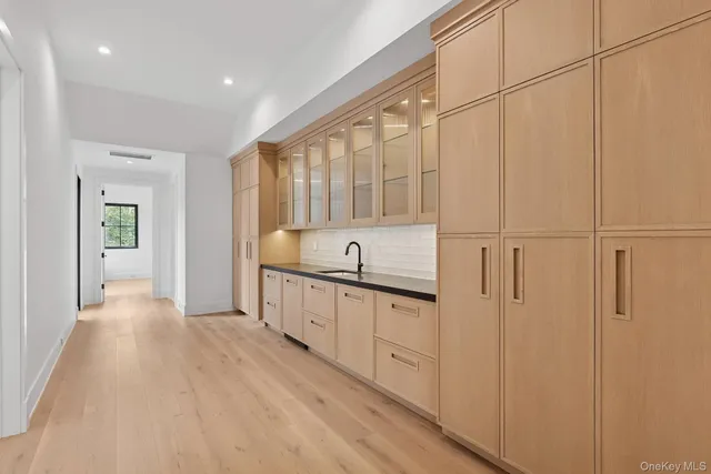 a large white kitchen with white cabinets and sink