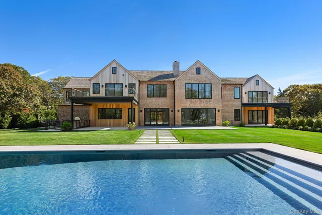 a front view of a house with a yard and trees