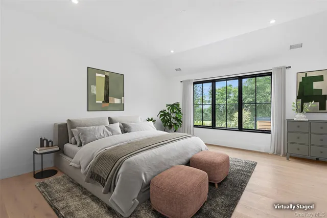 a bedroom with a bed and a large window