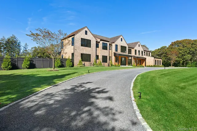 a view of a white house with a big yard and large trees