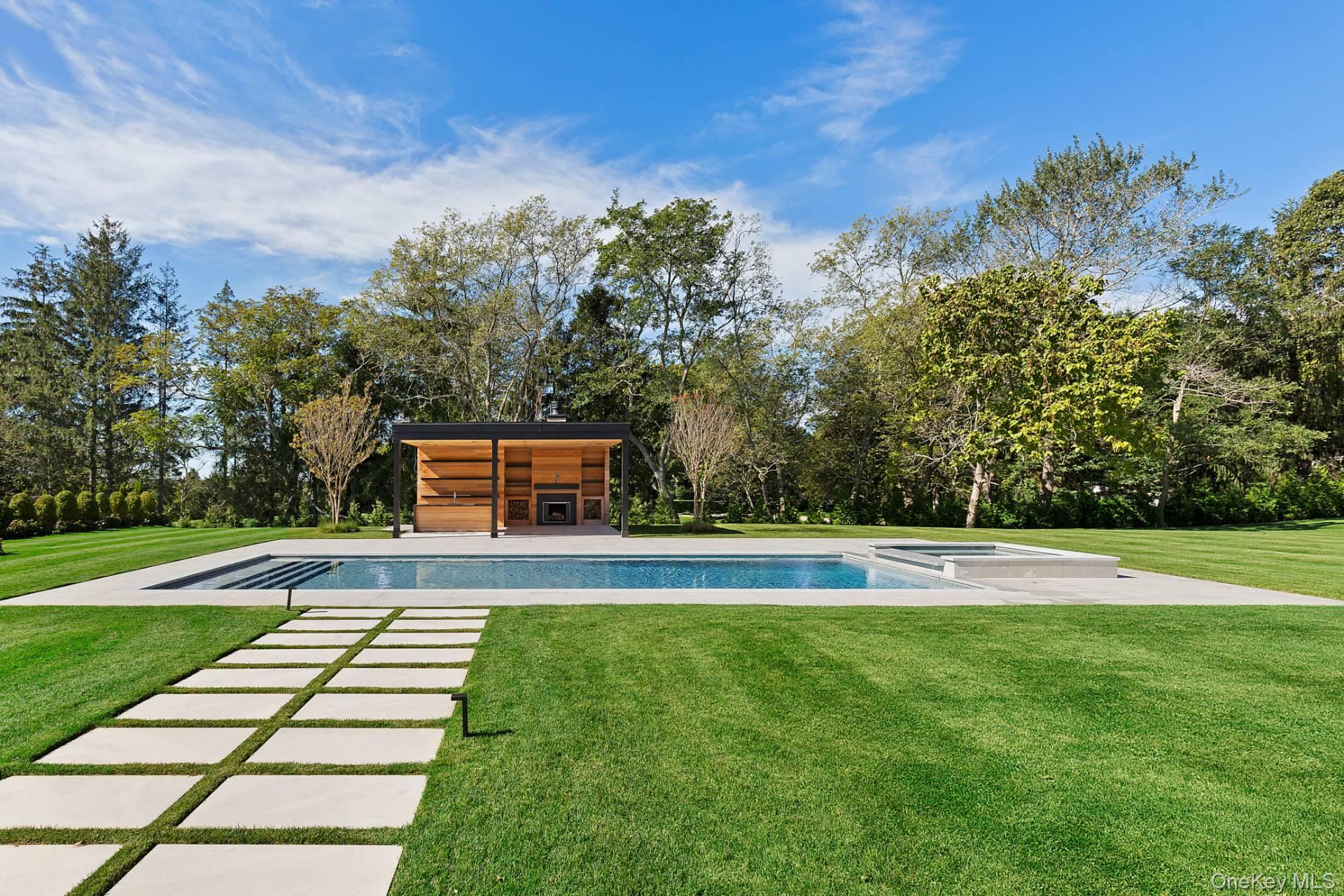 150 Edge Of Woods Road Southampton, NY 11968 - Photo 8 of 47 a view of swimming pool with a yard and large trees
