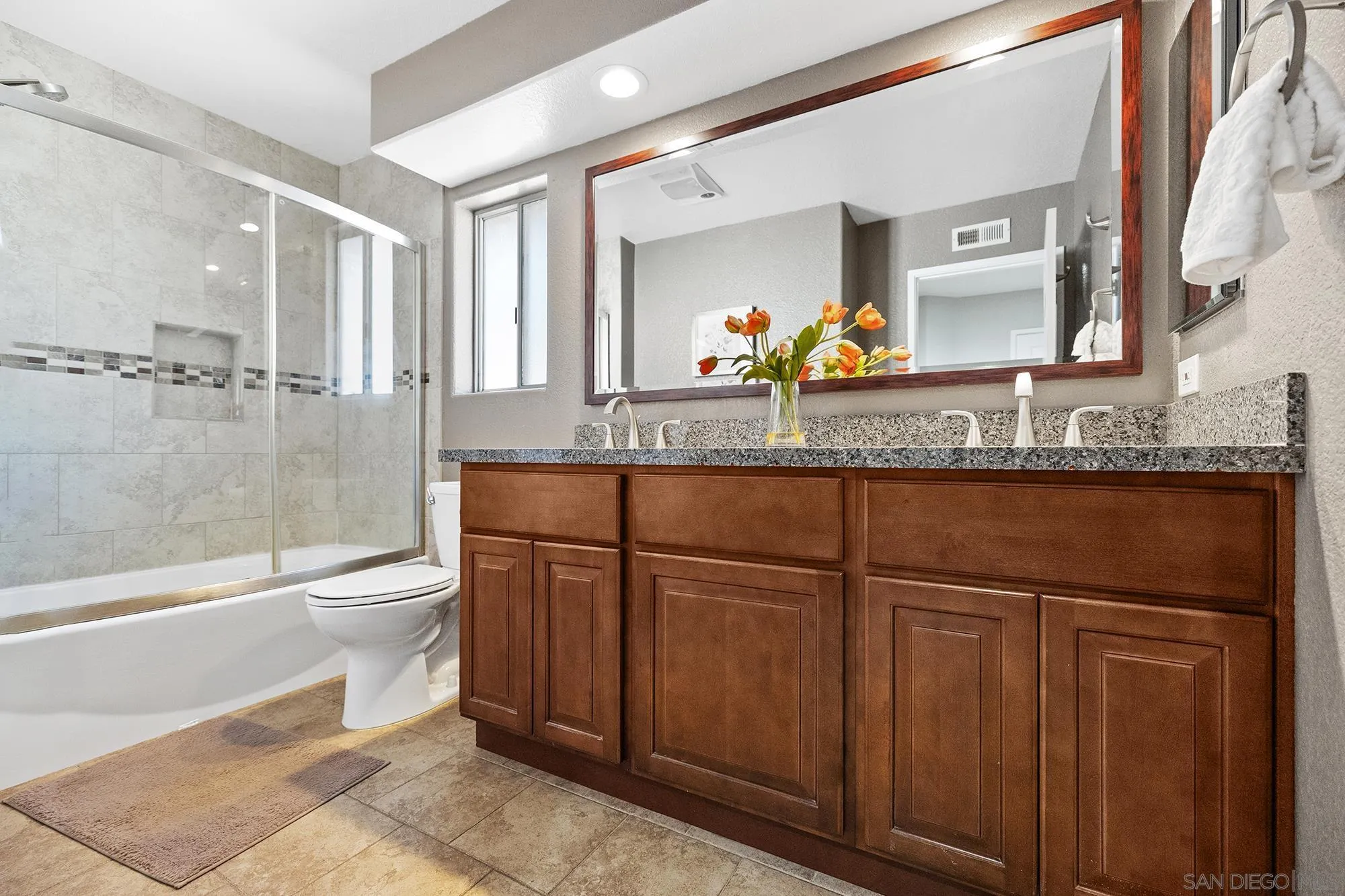 13958 Carriage Road Poway, CA 92064 - Photo 11 of 35 a bathroom with a granite countertop sink toilet a large mirror a bathtub and shower
