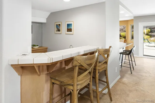 a view of a kitchen with granite countertop a sink and chairs