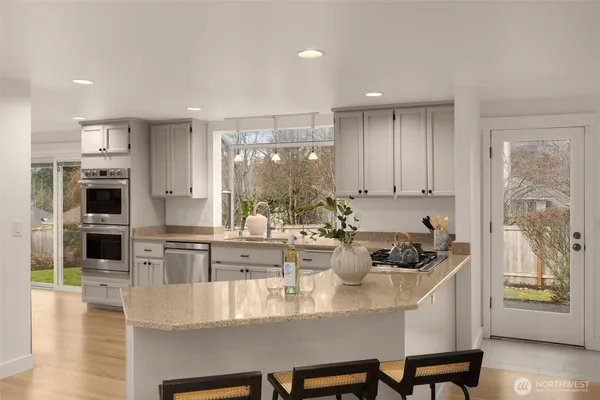 a kitchen with a dining table chairs and stove