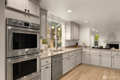 a kitchen with stainless steel appliances granite countertop a stove sink and cabinets