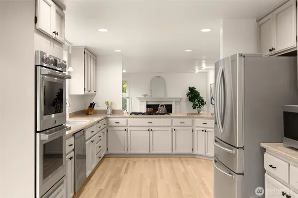 a kitchen with white cabinets and stainless steel appliances