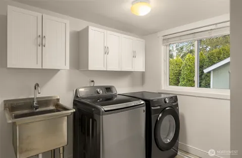 a utility room with sink dryer and washer