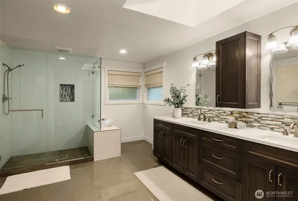 a spacious bathroom with a double vanity sink a large mirror and a shower