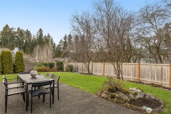 a view of a backyard with table and chairs and wooden fence