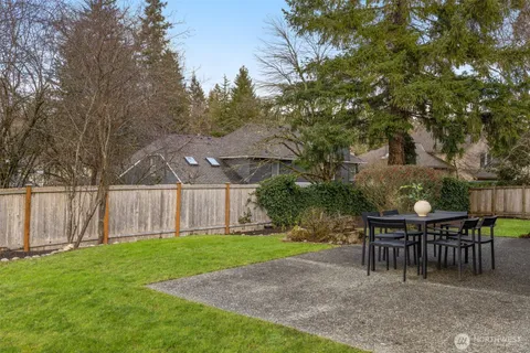 a view of backyard with seating and trees