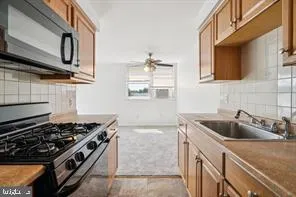 a kitchen with stainless steel appliances granite countertop a sink stove and cabinets
