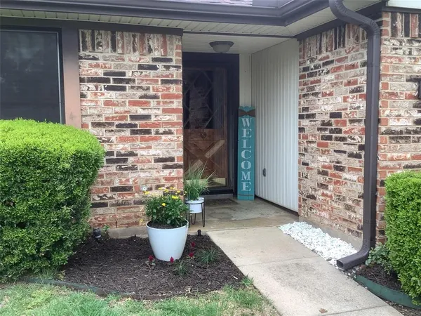 a view of a door of the house with potted plants