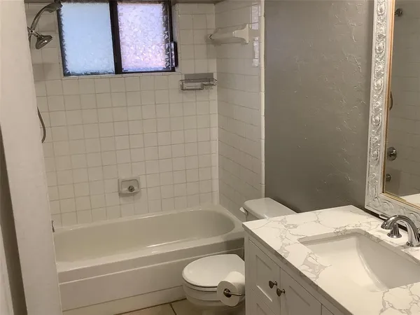 a bathroom with a granite countertop toilet a sink and bathtub