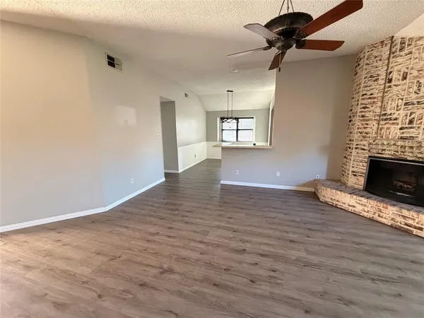 a view of empty room with wooden floor and fireplace