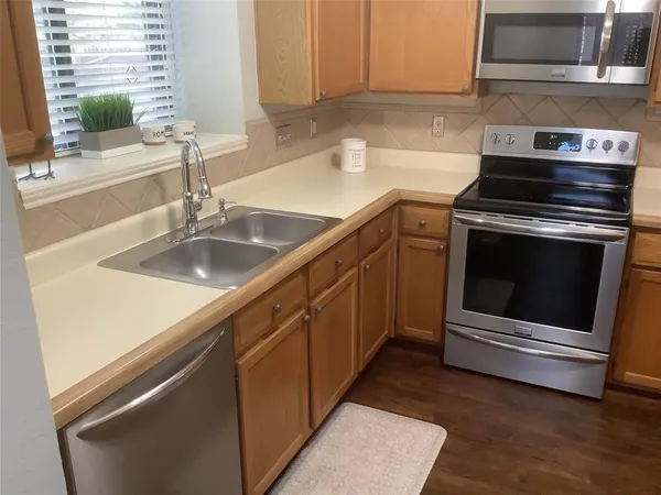 a kitchen with granite countertop a sink stove and cabinets