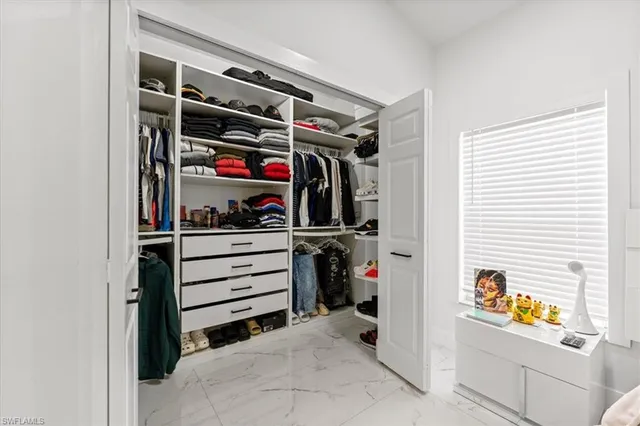 a view of walk in closet with clothes and shoes