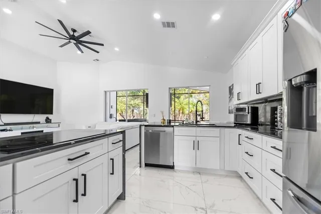 a kitchen with white cabinets and appliances
