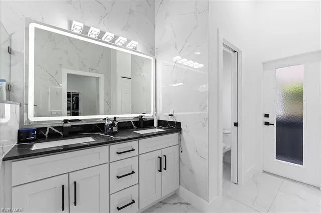 a bathroom with double sink and a mirror