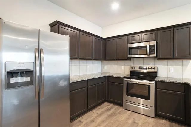 a kitchen with a refrigerator stove and microwave