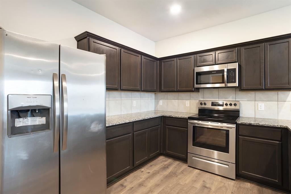 2328 Stefani Street Anna, TX 75409 - Photo 5 of 23 a kitchen with a refrigerator stove and microwave