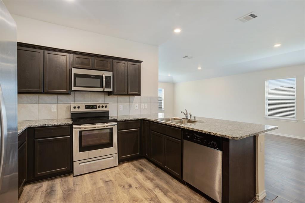 2328 Stefani Street Anna, TX 75409 - Photo 6 of 23 a kitchen with a sink stove and microwave