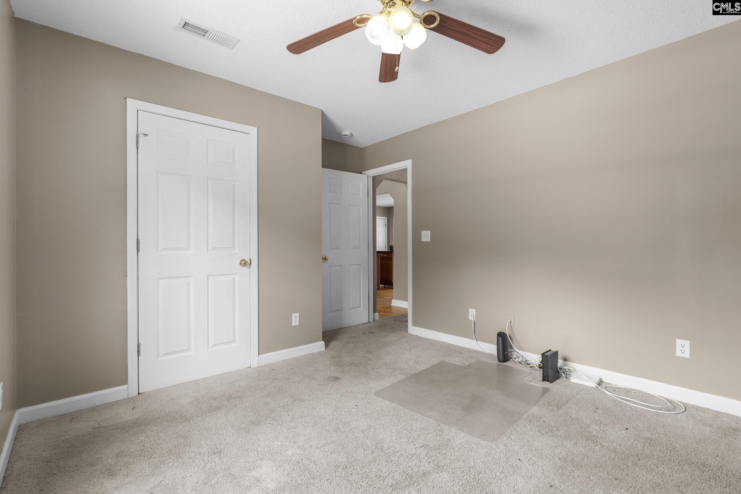 548 Eskie Dixon Road Elgin, SC 29045 - Photo 18 of 27 an empty room with chandelier fan and windows