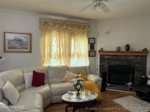 a living room with furniture a fireplace and a chandelier