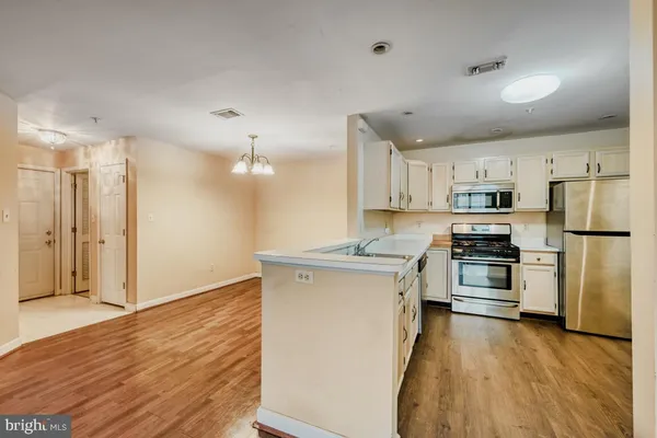 a kitchen with stainless steel appliances granite countertop a sink a stove a refrigerator and a oven