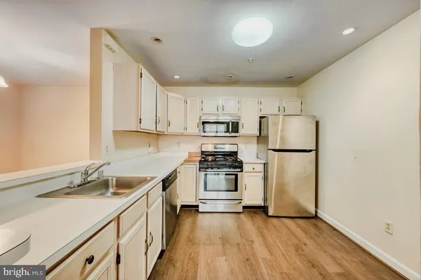 a kitchen with a sink a refrigerator and a stove top oven