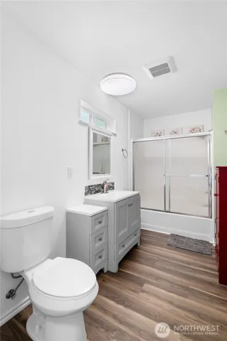 a bathroom with a granite countertop toilet a sink and mirror