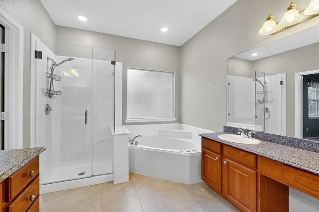 a bathroom with a tub sink shower and mirror