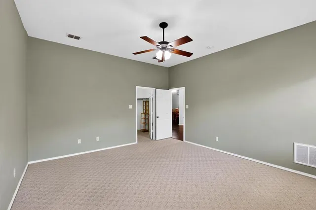 an empty room and chandelier fan