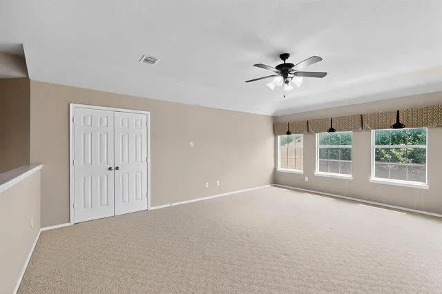a view of a livingroom with a ceiling fan and window