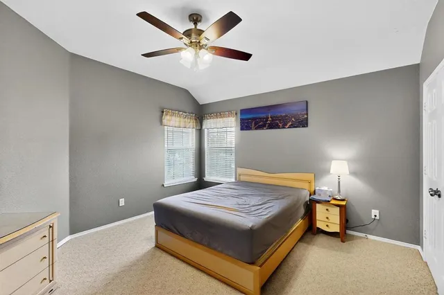 a bedroom with a bed and a ceiling fan