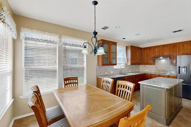 a kitchen with stainless steel appliances granite countertop a sink a stove and a refrigerator