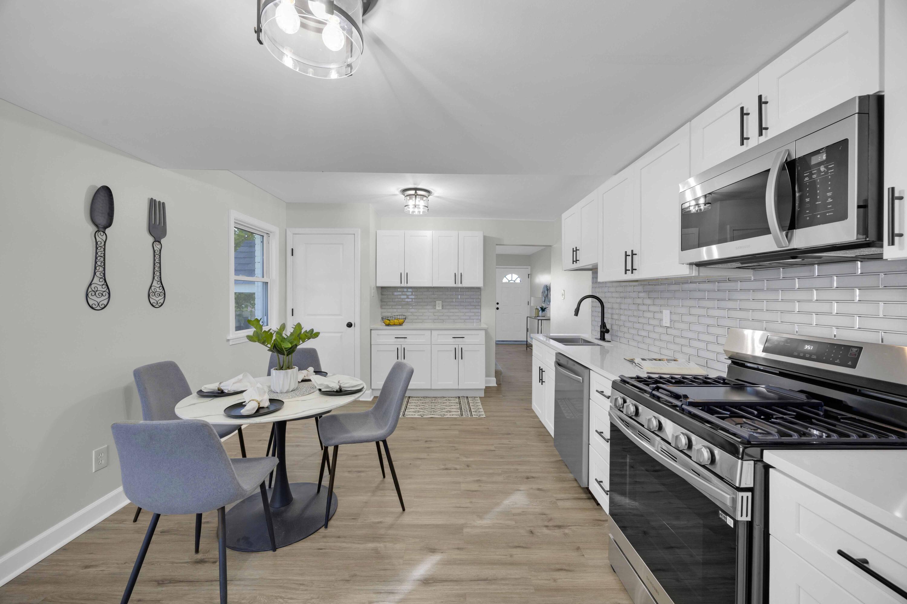 5428 Chestnut Avenue Hammond, IN 46320 - Photo 5 of 20 a kitchen with stainless steel appliances a stove a sink cabinets and a dining table