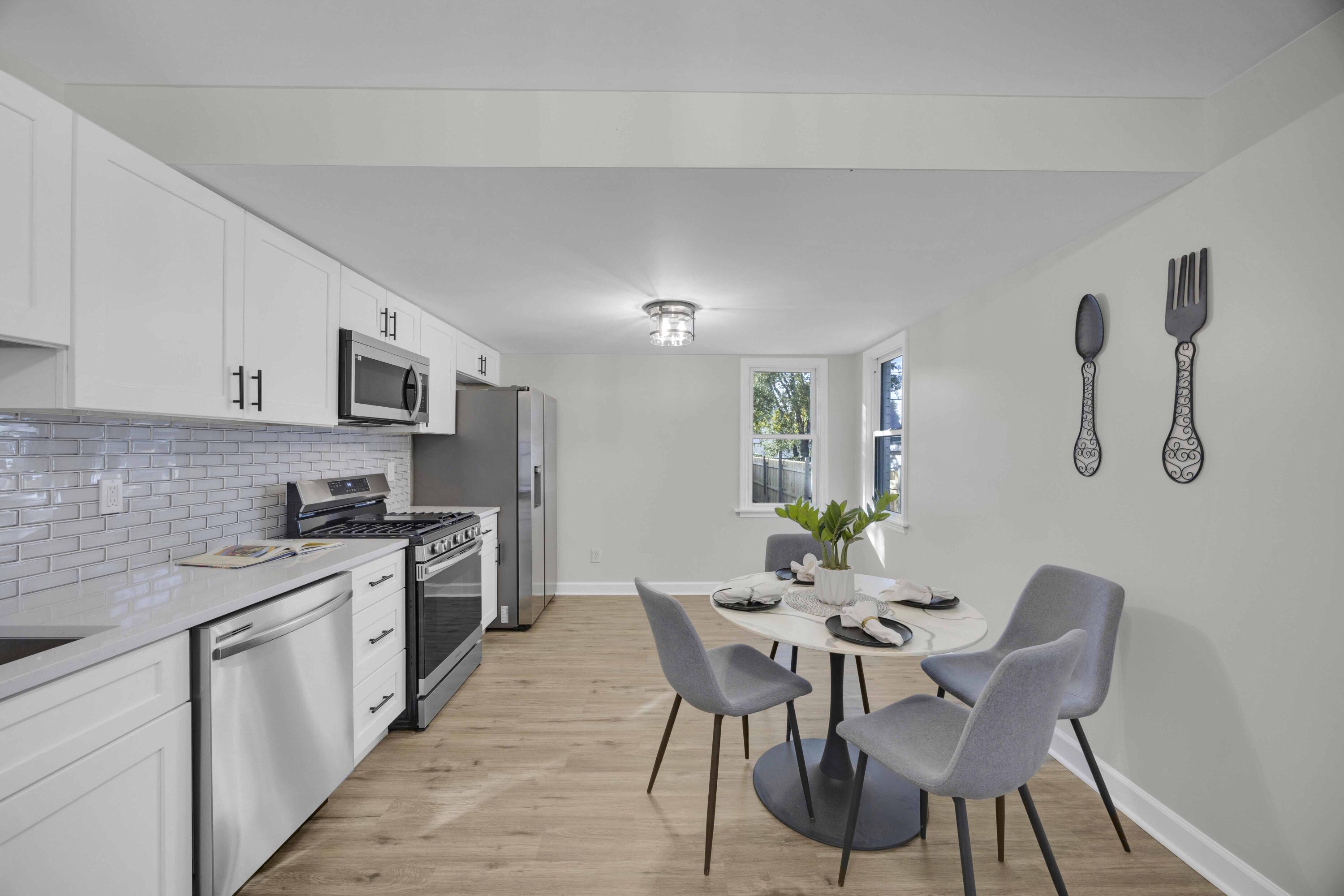5428 Chestnut Avenue Hammond, IN 46320 - Photo 7 of 20 a kitchen with stainless steel appliances a table chairs microwave and cabinets