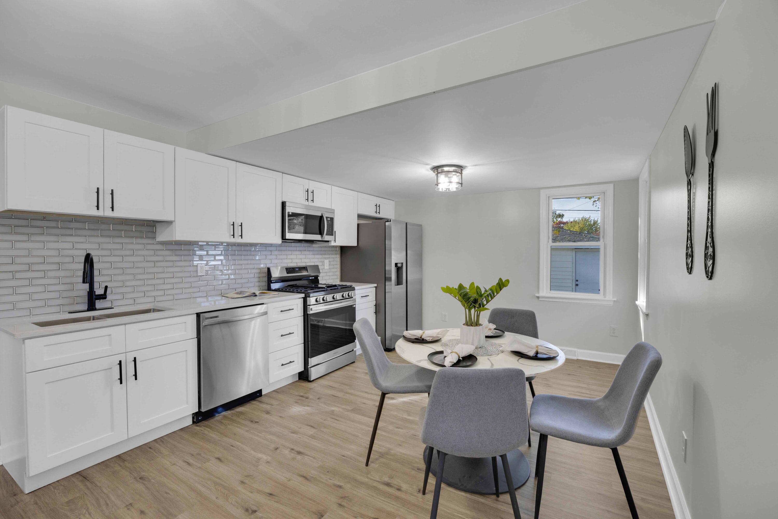 5428 Chestnut Avenue Hammond, IN 46320 - Photo 8 of 20 a kitchen with stainless steel appliances granite countertop a kitchen island hardwood floor sink and stove