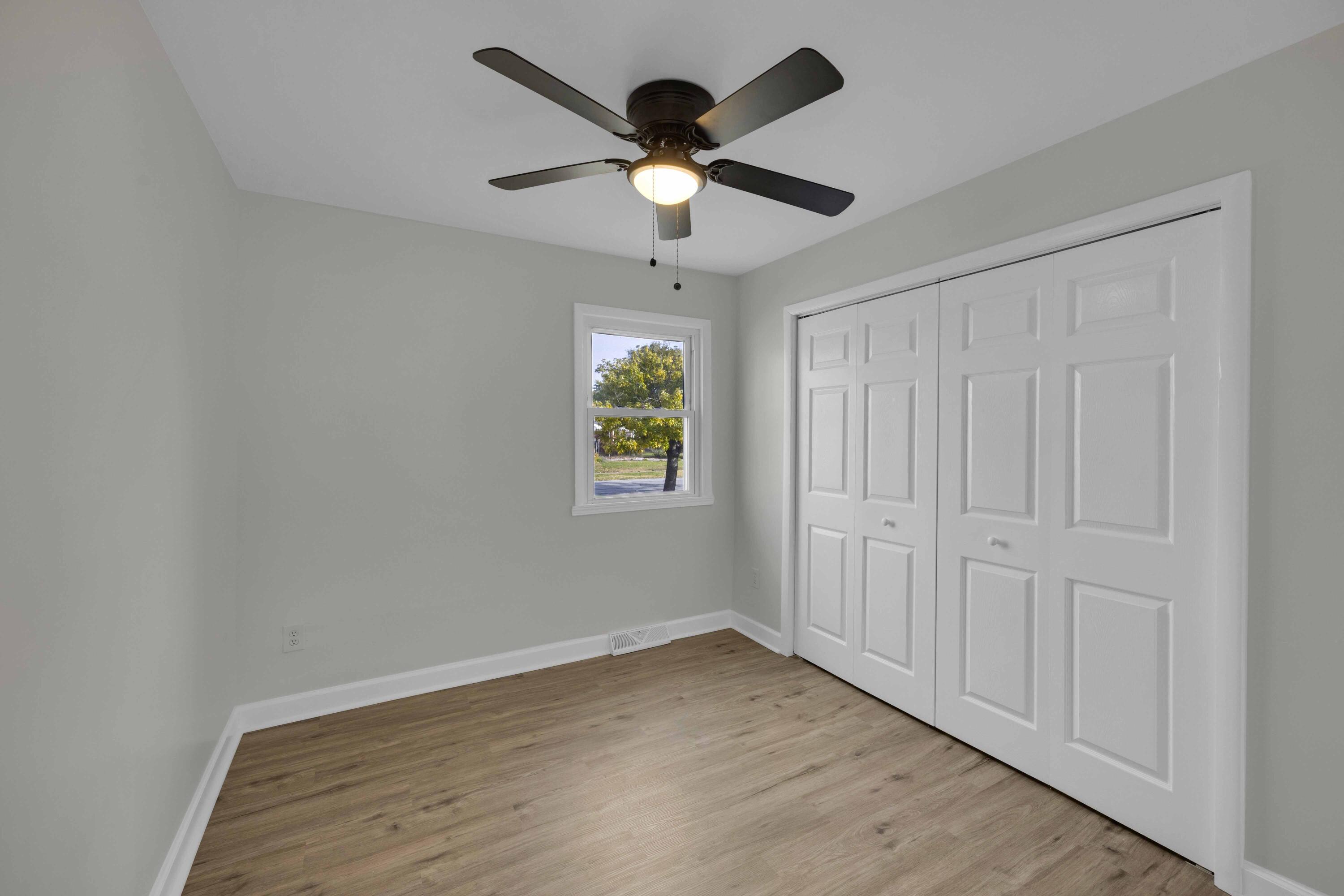 5428 Chestnut Avenue Hammond, IN 46320 - Photo 10 of 20 an empty room with wooden floor ceiling fan and window