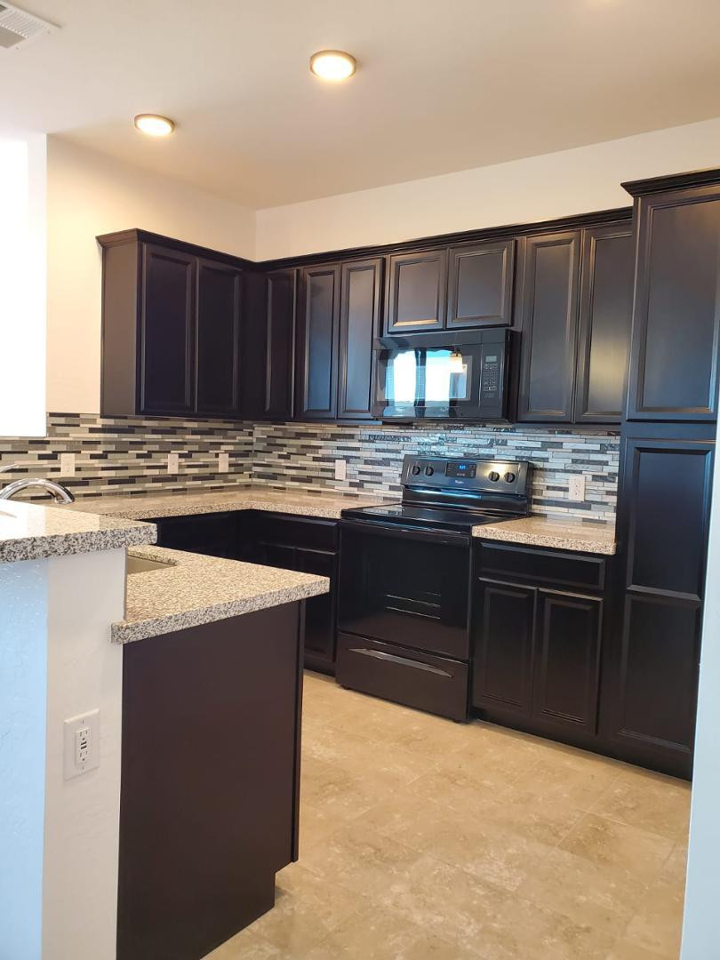 3900 East Baseline Road, Unit 118 Phoenix, AZ 85042 - Photo 29 of 32 a kitchen with stainless steel appliances kitchen island granite countertop a stove a sink and a refrigerator