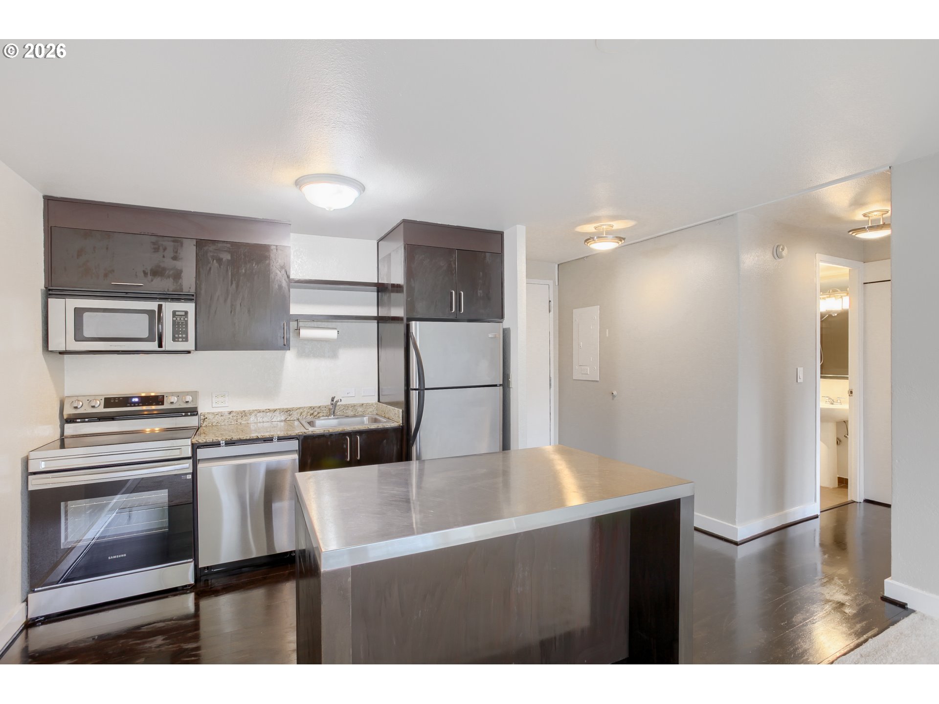 111 Southwest Harrison Street, Unit 4G Portland, OR 97201 - Photo 7 of 13 a kitchen with kitchen island a stove and a refrigerator