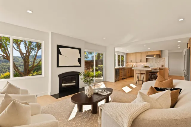 a very nice looking living room with a large dining table and a large window with kitchen view