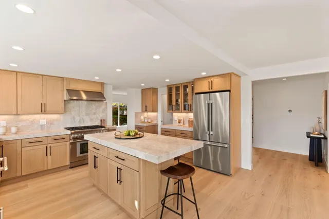 a kitchen with stainless steel appliances granite countertop a sink and a refrigerator
