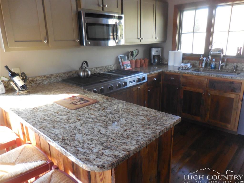 1071 Elk Hill Road Banner Elk, NC 28604 - Photo 14 of 28 a kitchen with stainless steel appliances granite countertop a sink a stove and a microwave