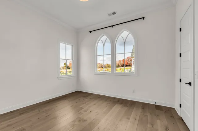 a view of empty room with wooden floor