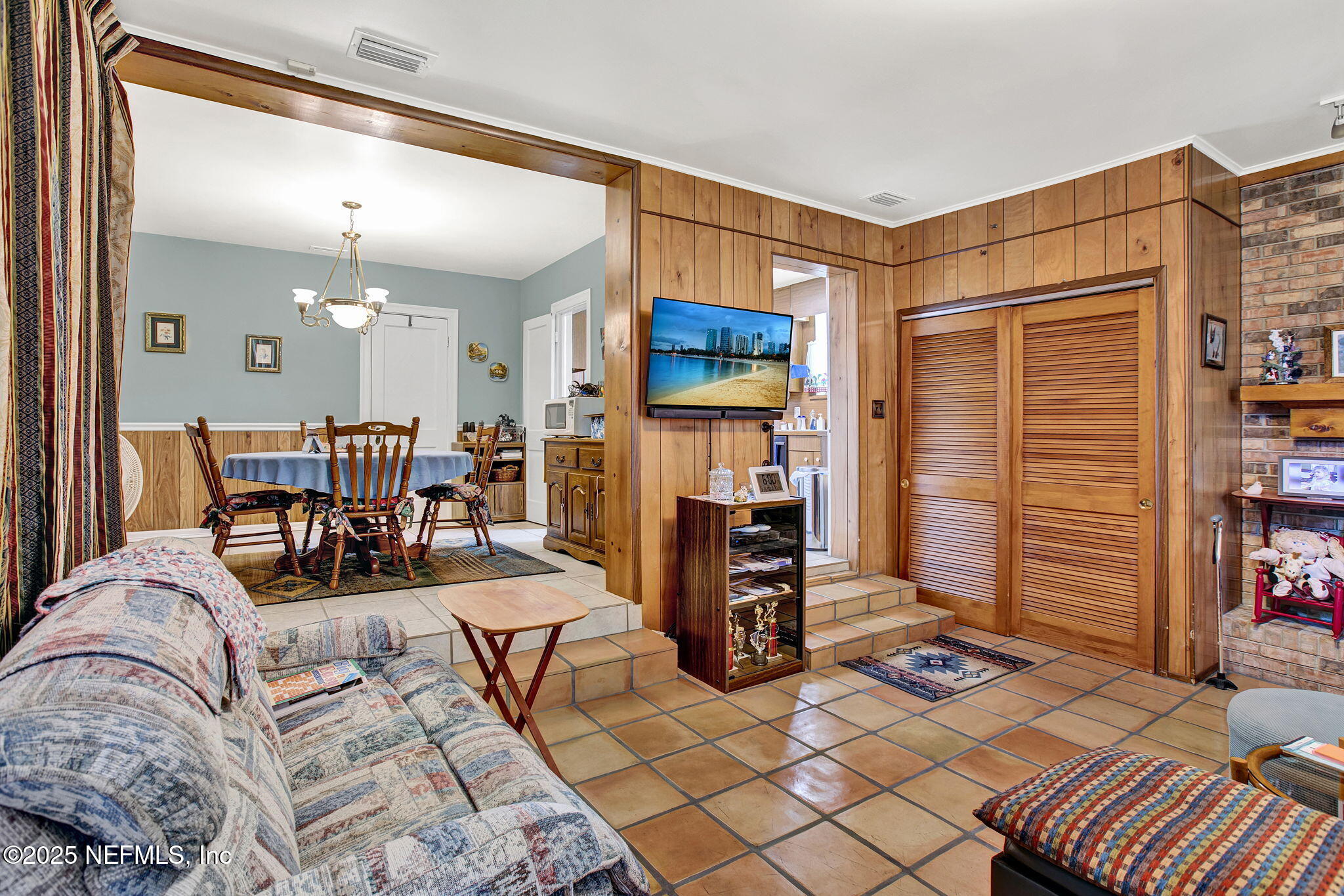 1105 South Shores Road Jacksonville, FL 32207 - Photo 17 of 31 a living room with furniture a flat screen tv and a refrigerator