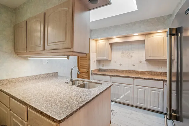 a kitchen with refrigerator a sink and chairs