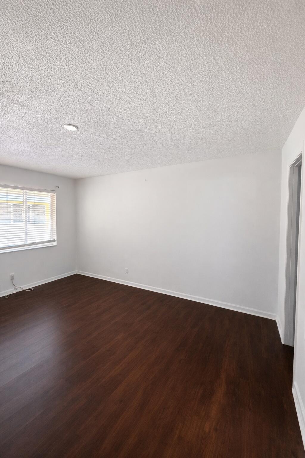 635 Southwest 14th Terrace, Unit 19 Fort Lauderdale, FL 33312 - Photo 6 of 8 an empty room with wooden floor and windows